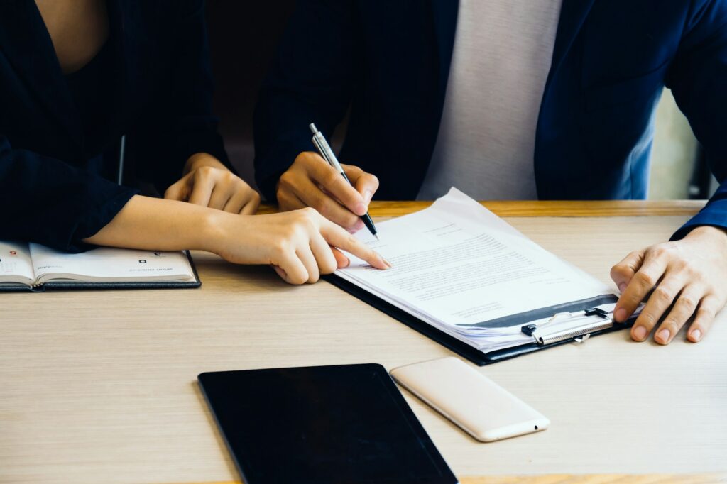 Businessman and businesswoman signing paper (insurance, contract, important)